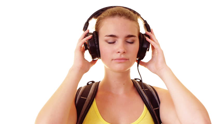 Smiling schoolgirl with backpack  listening music