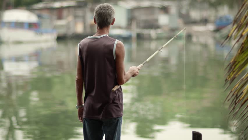 Retired elderly people, hobby and leisure activities, old man fishing near the sea. Dolly shot