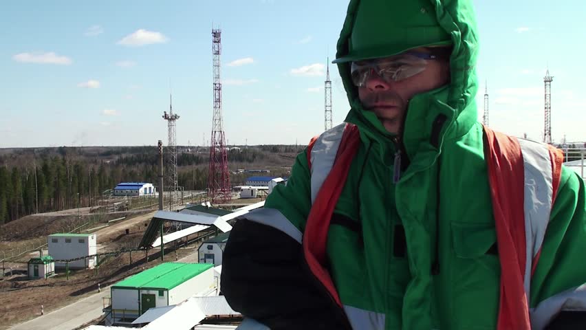 Worker on a top of a huge oil tank