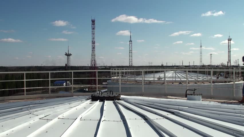 Worker on a top of a huge oil tank