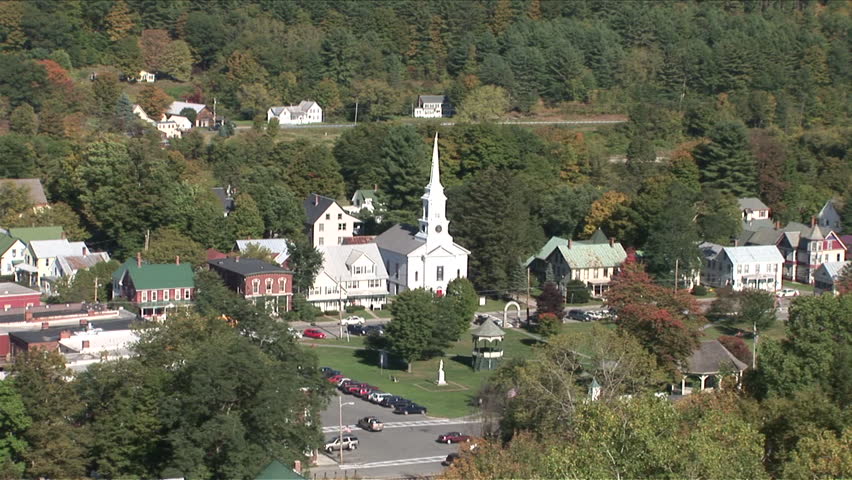 Wide view of a quiet country town in the middle of a forest with a church