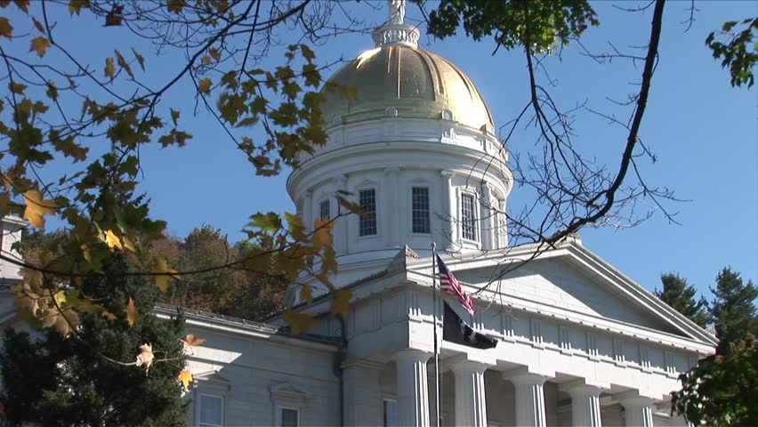 Montpelier, Vermont - CIRCA September 2007: Zoom out of the State Capitol Building sitting on a green lawn with trees during the day