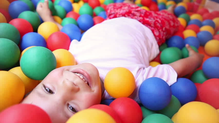 three year old boy in a pool of coloured balls
