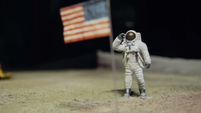 Astronaut or spaceman working on moon, salute the USA flag.