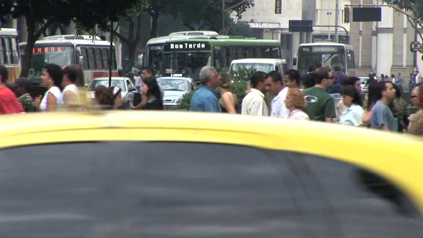 RIO DE JANEIRO, BRAZIL - CIRCA 2010: Crowds of People Crossing A Street AS A Car Comes To A Sudden Stop In Rio De Janeiro, Brazil