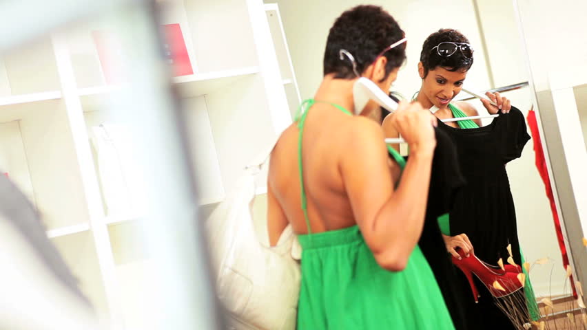 Female Asian Chinese store manager showing merchandise to African American customer