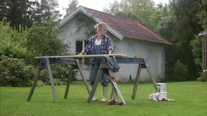 A woman doing carpentry in a garden