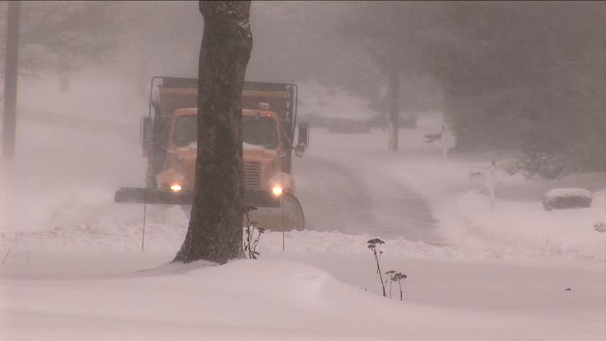 NEW ENGLAND - CIRCA JANUARY 2006: City snowplow plowing residential street in snowstorm