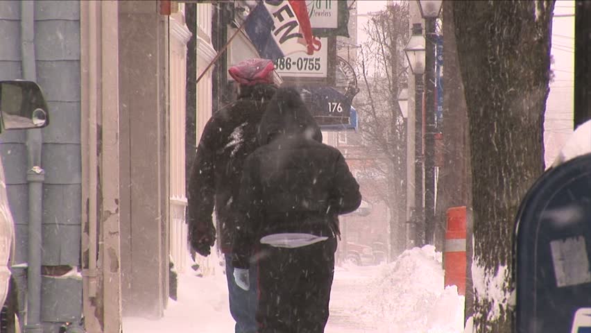 NEW ENGLAND - CIRCA JANUARY 2006: People walking along a sidewalk in blizzard