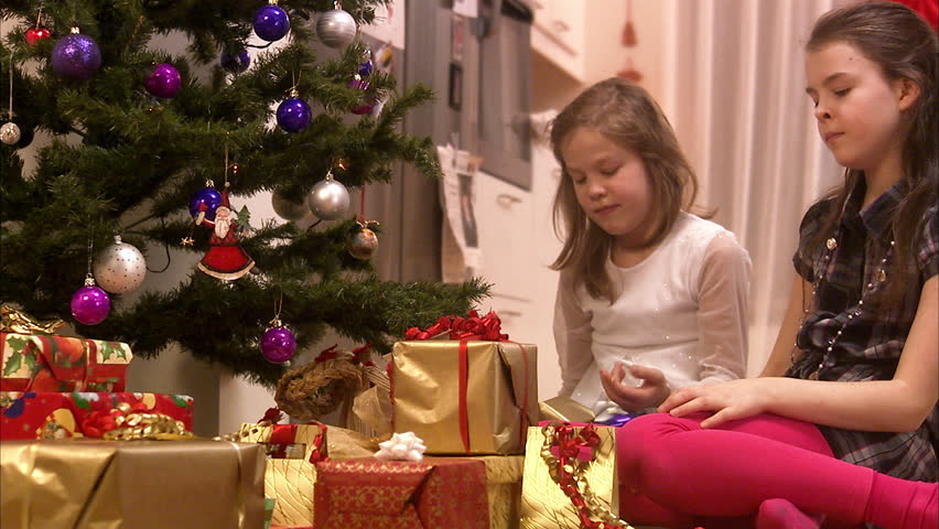 Girls sitting by the Christmas tree
