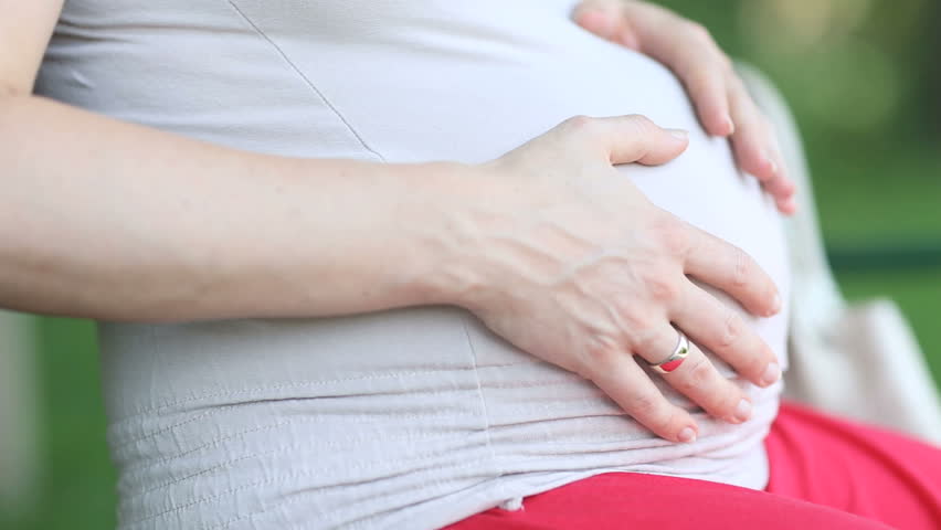 close up woman touching her pregnant belly