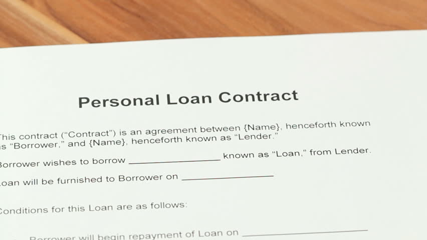 Loan Application - Woman going over a personal loan contract and signs it on the borrower signature line