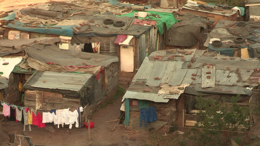 Informal settlements close together in Durban, people going  in and out of their shacks.