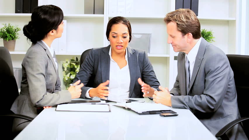 Female African American business executive leading meeting with multi ethnic team