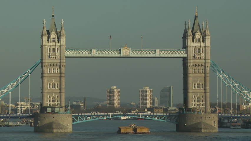 London, England Circa 2011. Wide shot of the Pool of London with  City skyline in the background and moored boats in the foreground a tug tows refuse waste barges downstream