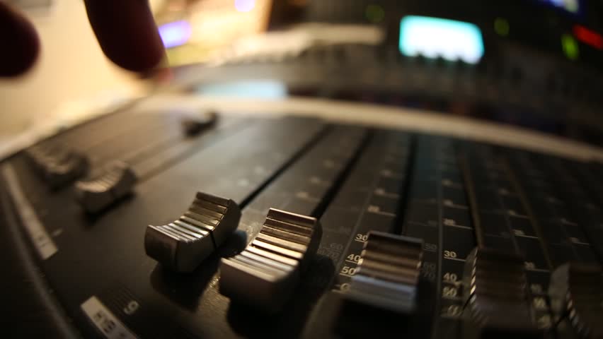 Sound director working on audio mixer in professional studio. Sharp near of hand, a little DOF.