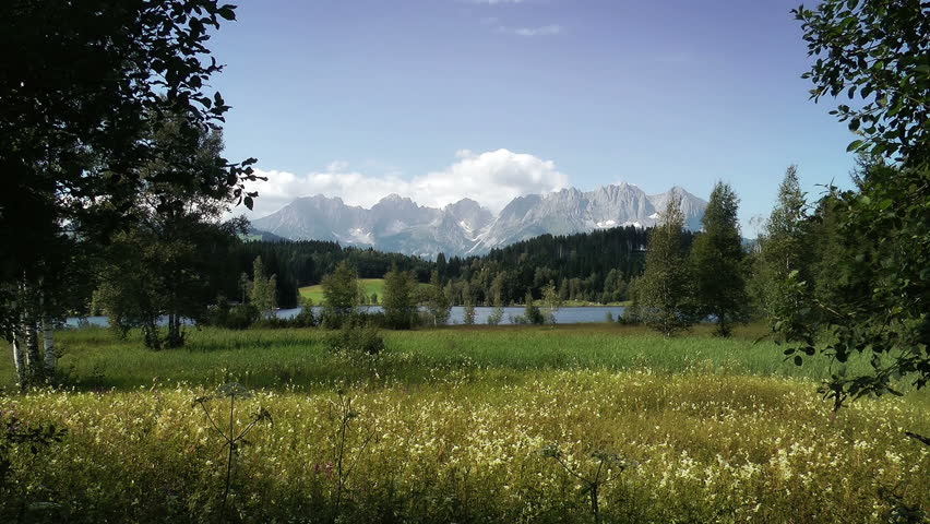 Mountain And Lake Panoramic View. The Austrian Alps in the distance and the Schwarzsee lake of Kitzbuhel glistening below.