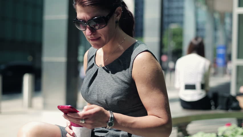 Businesswoman with smartphone in the city, steadicam shot
