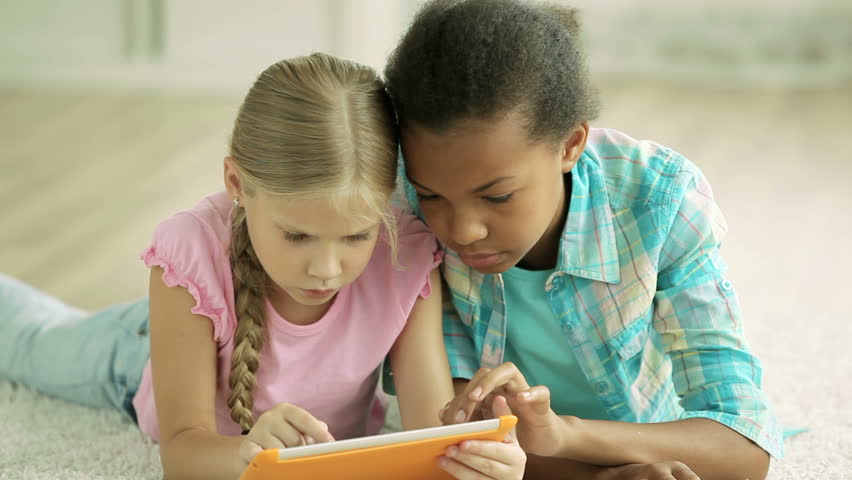 Classmates mastering their computer skills using a digital tablet