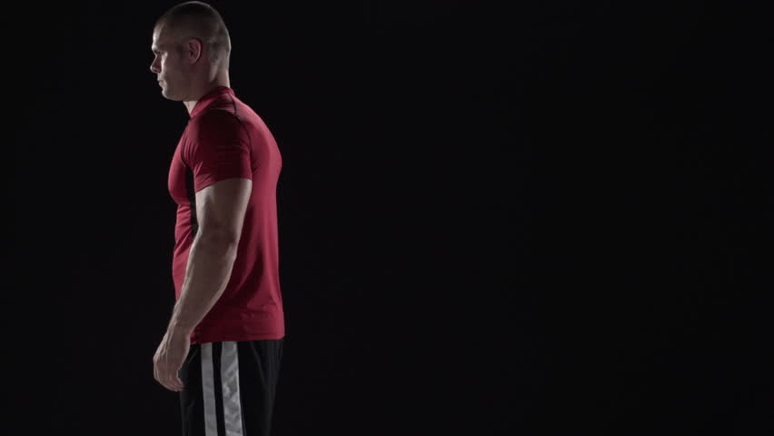 Man does back flip in slow motion, black background