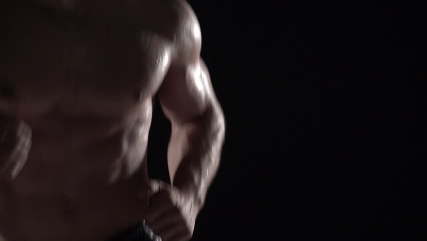 Muscular man running towards camera, torso shot left