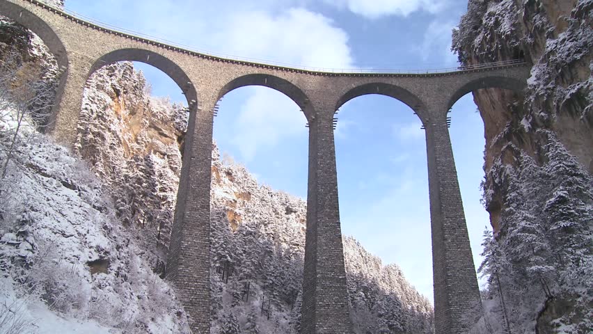 LANDWASSER VIADUCT, SWITZERLAND-CIRCA 2011-A train in Europe crosses a remarkable bridge and plunges directly into a tunnel.