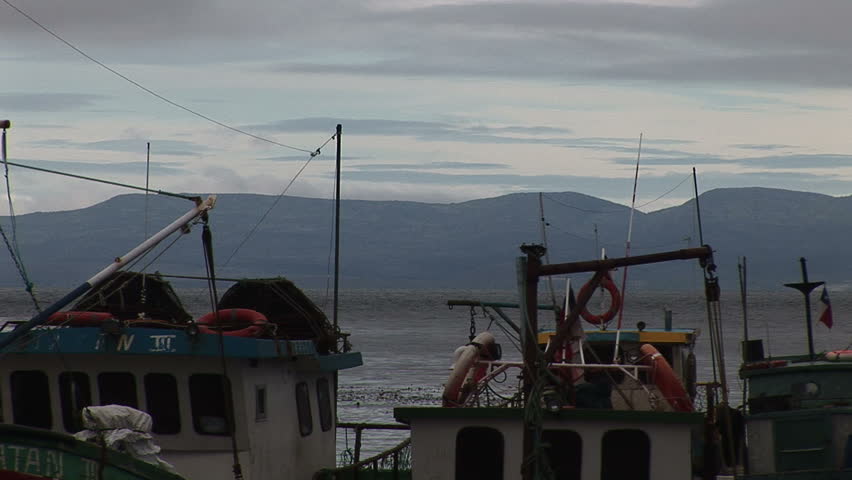 Boats at a seaport in Punta Arenas, Chile on an overcast day