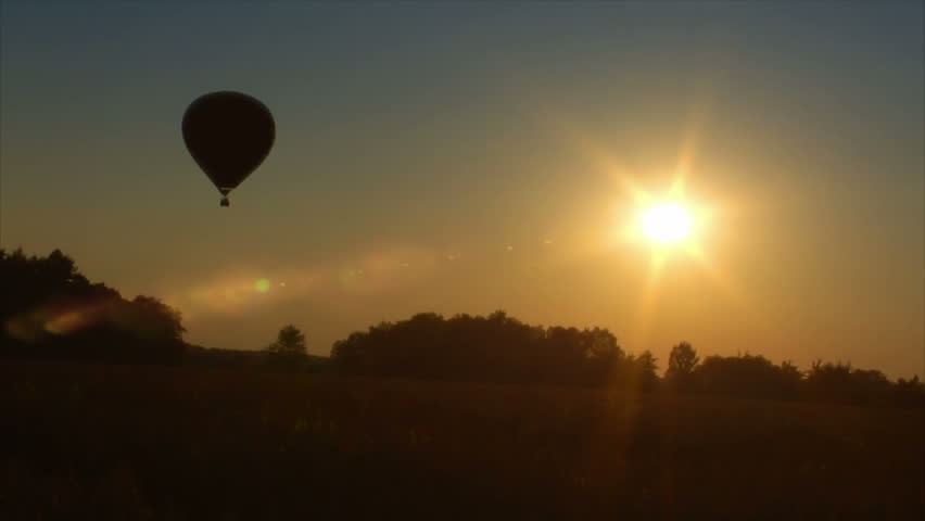 A hot air balloon lift off in sunrise / sundown.
