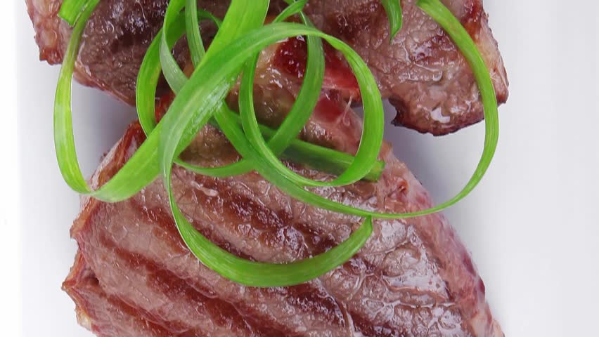 roasted beef meat strips on white ceramic plate isolated over white background