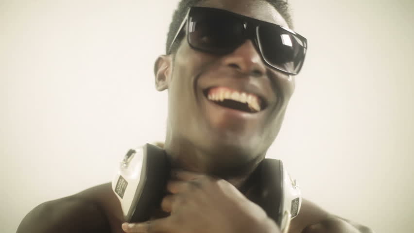young african guy waving and dancing with a cool attitude and smiling to the camera