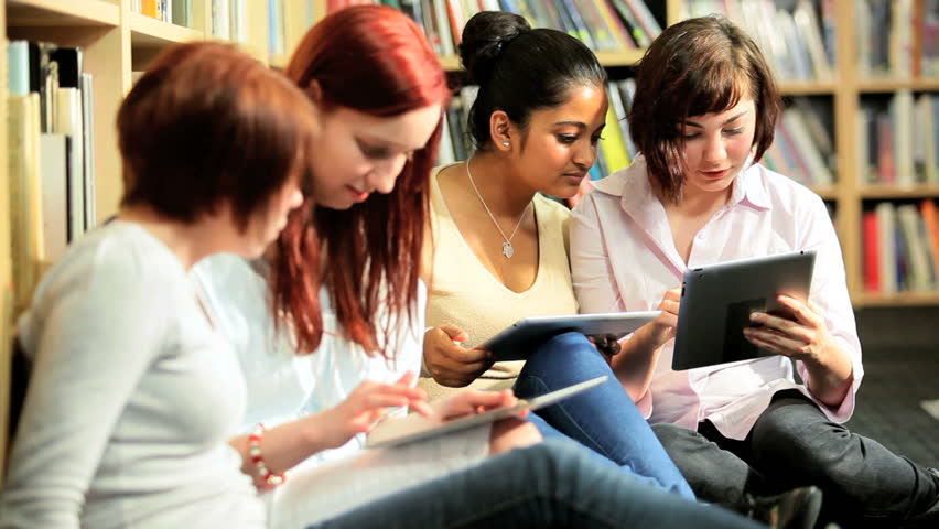 Diverse female friends learning modern communication technology in university