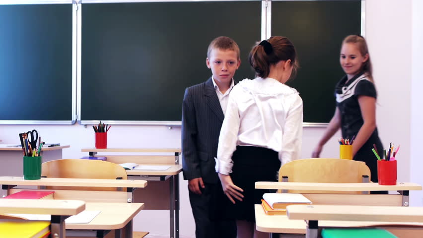 Happy young pupils walking in the classroom for lessons