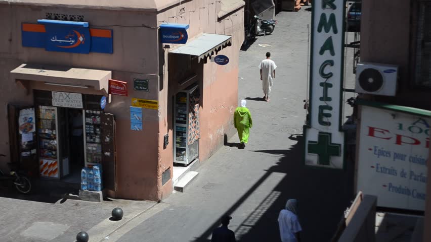 MARRAKECH, MOROCCO - CIRCA 2012: People walk in the street at midday circa July 2012 in Marrakech, Morocco.