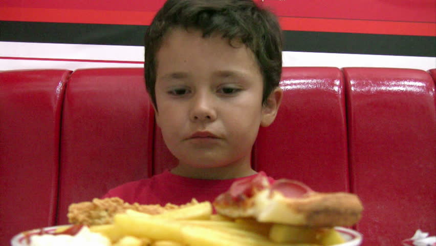 Little boy eating pizza and fries