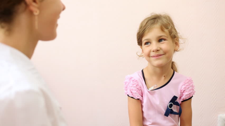 woman doctor takes from girl in pink thermometer from armpit, looks temperature and leaves