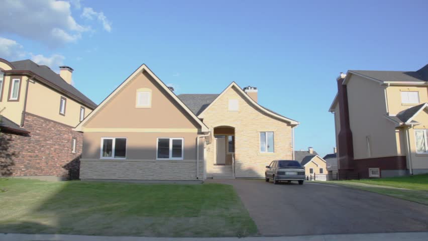 Suburban neighborhood pov, Many cottages in village under blue sky with clouds at sunny summer day, carview in motion