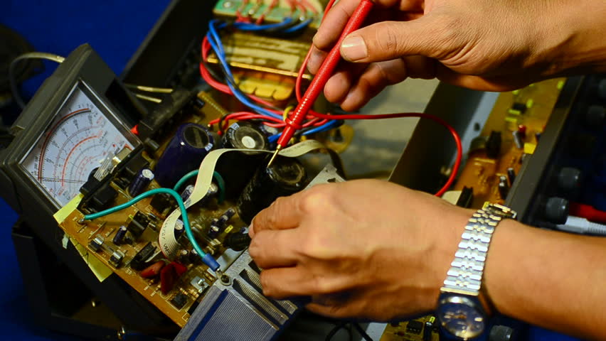 Electrician using voltmeter for checking and repair office equipment