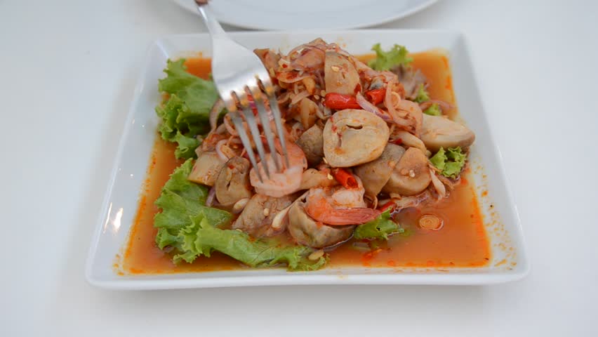Spicy mingle mushroom salad gourmet. A person eating spicy Thai cuisine as main dish.