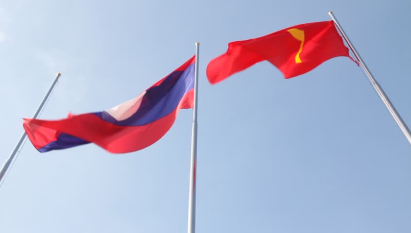 Laos and Communist flag waving against blue sky in Vientiane Laos
