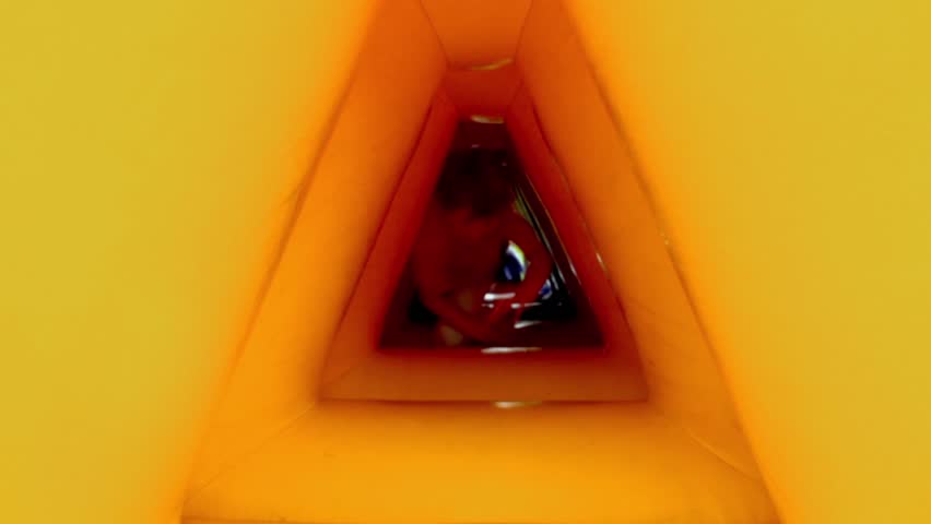 Little boy crawls through inflatable tunnel and smiles
