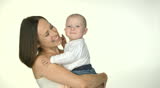 happy mother kissing her baby and smiling in studio