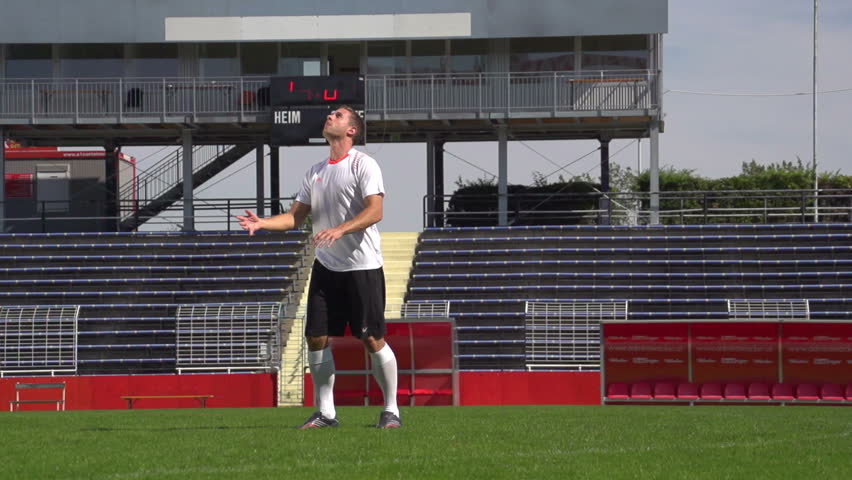 soccer player in slow motion during overhead kick on playing field
