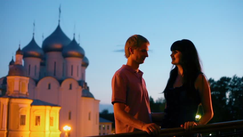Young couple hold hand during date near Saint Sofia cathedral at night in Vologda, Russia