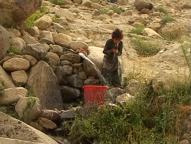 Child washing face in spring water