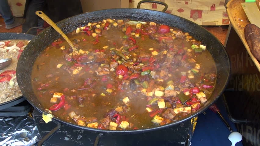 Meat and vegetable stew cooking in a big cast iron pot
