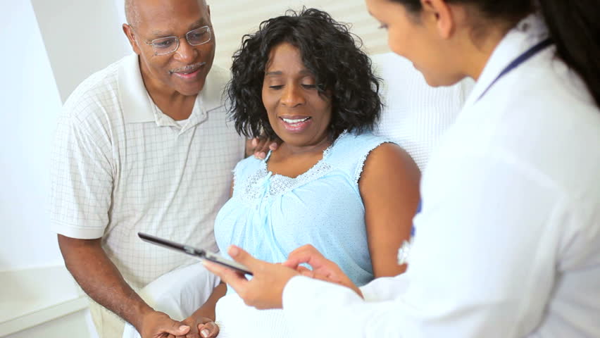 Latin American nurse showing senior ethnic female patient care plan recorded on wireless tablet