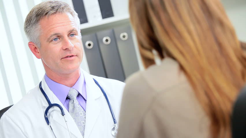 Female pharmaceutical representative discussing clinical trial results Caucasian doctor in his office