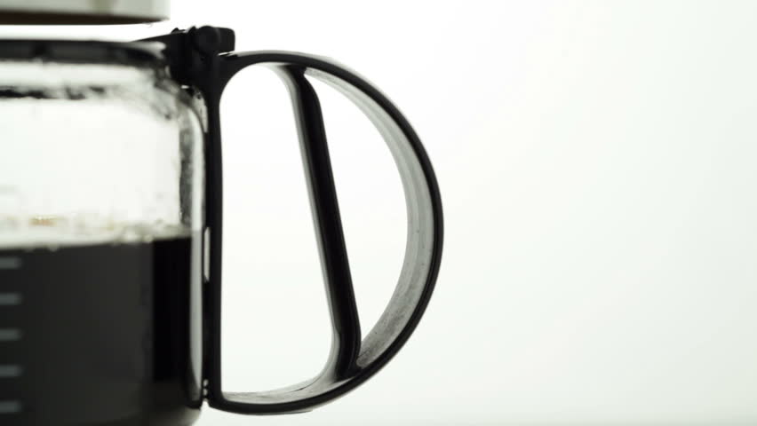Coffeemaker, slow panning and zooming from the coffee decanters handle to the scale and the drops