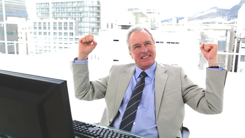 White hair businessman the fists raised sitting in his office
