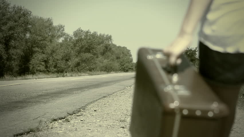 Young woman with guitar on the road and her vintage baggage